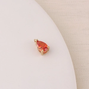 Macro view of pear-cut orange zircon pendant in gold plating for DIY jewelry