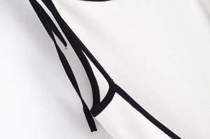 Gros plan sur le nœud papillon contrasté et la maille texturée de la mini robe