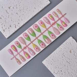 Detail of 3D almond press-on nails with floral carvings and summer fruit textures