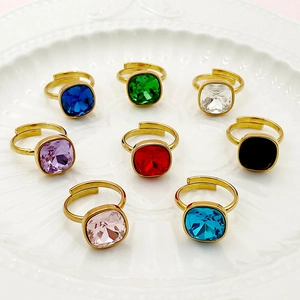 Ensemble de huit bagues en acier doré serties de zircons carrés de différentes couleurs