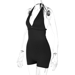 Detail view of black halter neck romper with backless design and pleated texture