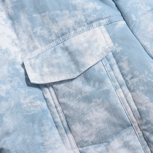 Détail de la poche cargo sur veste matelassée en sergé avec dégradé de bleu et blanc