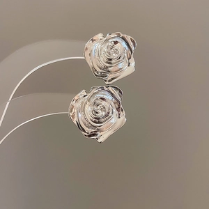 Vista dettagliata di orecchini a rosa d'argento con petali metallici lucidi