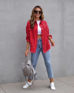 Outdoor-Foto der roten Denim-Jacke im Used-Look mit ausgefransten Kanten und Oversize-Passform