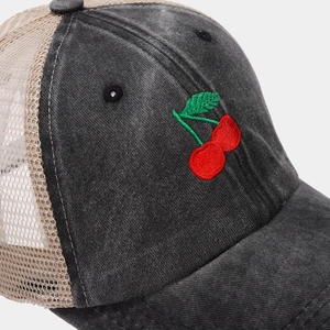 Detail of red cherry embroidery and breathable mesh on washed dark gray baseball cap