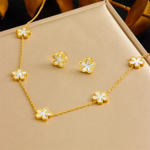 Minimalist golden flower jewelry set with white shell petals on display box