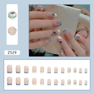 French cream and blue press-on nails set with glitter stars and diamond accents