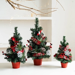 Set of three mini Nordic Christmas trees with red berries and pine cones on table