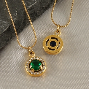 Detailed close-up of double-sided round 18K gold pendant with green stone and pavé gems