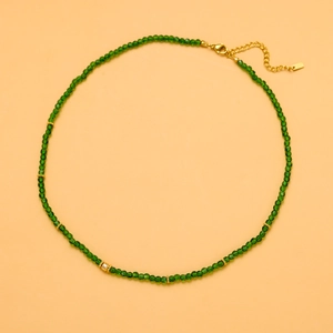 Close-up of deep green faceted crystal beads with golden lobster clasp and extender chain