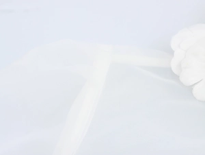 Detail of white sheer organza fabric with 3D floral decoration and stitching texture