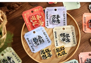 Close-up of traditional Chinese acrylic magnets with surnames and blessings in a tray