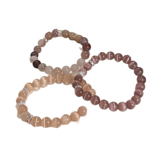 Tre eleganti bracciali con pietre occhio di gatto in rosa, grigio e champagne con ciondoli