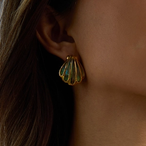 Elegant gold-tone shell earrings with rainbow abalone inlay worn by a model