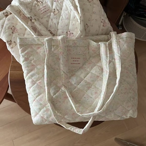 Detail of quilted cotton tote bag featuring cute dog and floral patterns with French label