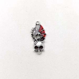 Macro shot of silver skull pendant with red wings for gothic jewelry making