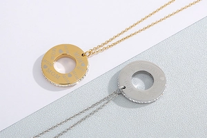 Detail of gold and silver heart necklaces featuring MOM engraving and pave set crystals