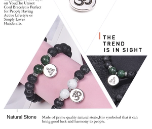 Macro detail of 10mm lava stone beads and silver OM charm on a yoga bracelet
