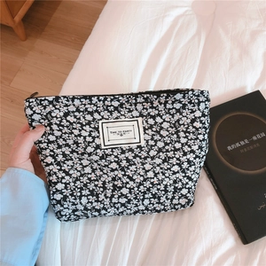 Close-up of floral makeup bag with Time to Party label and black white flower pattern