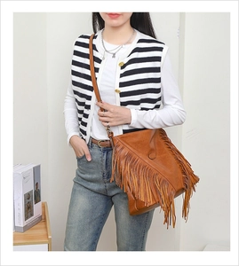 Détail d'un sac bandoulière marron avec de longues franges et une sangle réglable