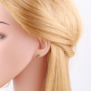 Macro shot of colorful zircon heart stud earrings worn on a model with golden hair