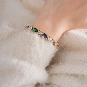 Macro detail of luxury vintage gold-tone bracelet with vibrant multi-color gemstones