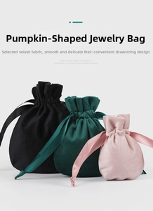 Detailed view of three velvet gourd pouches in black, dark green, and pink with satin drawstrings