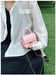 Detail of pink quilted jelly bag with gold chain strap and turn-lock on a model