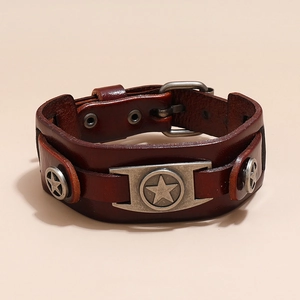 Dettaglio di un bracciale vintage in pelle marrone con ciondolo a stella e fibbia in metallo