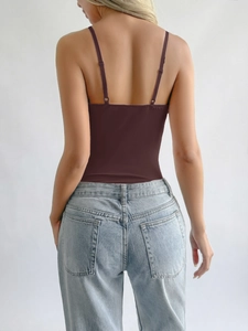 Deep brown backless bodysuit with thin straps and U-shaped cut paired with jeans