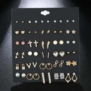 Detailed view of 30 pairs of gold and silver alloy earrings with rhinestones and pearls