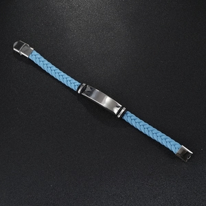 Macro view of a blue braided leather bracelet with a polished silver metal plate center