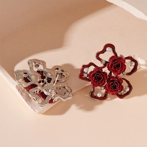 Detailed close-up of vintage red rose earrings with pearls and crystals on silver needles