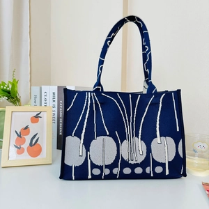Blue knitted tote bag with abstract white dandelion pattern and stylish wavy shoulder strap
