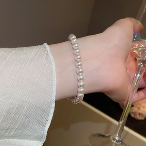 Gros plan d'un bracelet de perles plaqué or 18 carats avec zircons pour femme