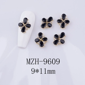 Detail of 9x11mm black clover nail charm with gold base and zircon stones for nail art