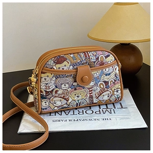 Detail of bear pattern tapestry fabric with brown leather trim and retro metal zipper