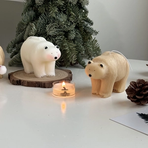 Polar bear candles with mini Christmas tree and pine cones in cozy holiday setting