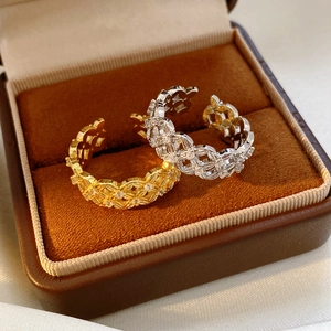 Close-up of gold and silver hollowed flower rings with zircons in a velvet box