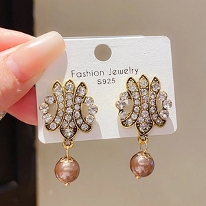 Détail de boucles d'oreilles vintage avec cristaux et perle marron sur tiges en argent S925