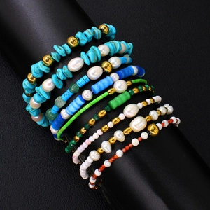 Detail of multi-layered bohemian bracelet set with turquoise stones and faux pearls