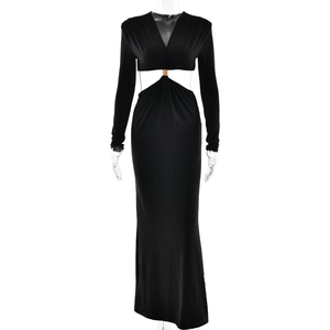 Detail view of deep V-neck black maxi dress with waist cut-outs and golden ring decoration
