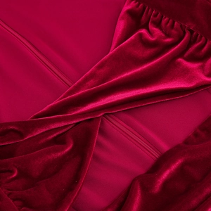 Vue macro d'une robe en velours bordeaux avec nœud croisé et fermeture éclair invisible