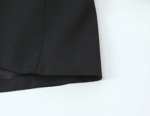 Gros plan du tissu noir de costume montrant la texture tissée fine et les coutures nettes