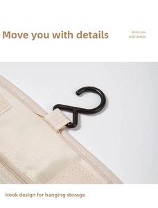 Detail showing the sturdy black hanging hook and velcro closure of the beige toiletry bag