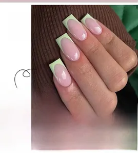 Detail view of square oval press-on nails with nude base and yellow French tips