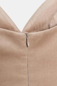 Detail eines unsichtbaren Reißverschlusses und weicher Samtstoff auf beigem Kleid