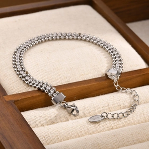 Macro detail of triple-strand 18K gold-plated bracelet with white zircons and K18 hallmark tag