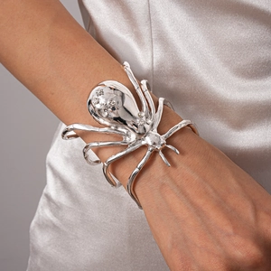 Macro shot of polished silver spider arm cuff with sparkling rhinestone crystal details