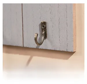 Detailed close-up of retro bronze metal wall hook mounted on a gray solid wood board
